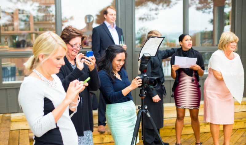 Samantha using her camera to capture special moments for her clients during a wedding 